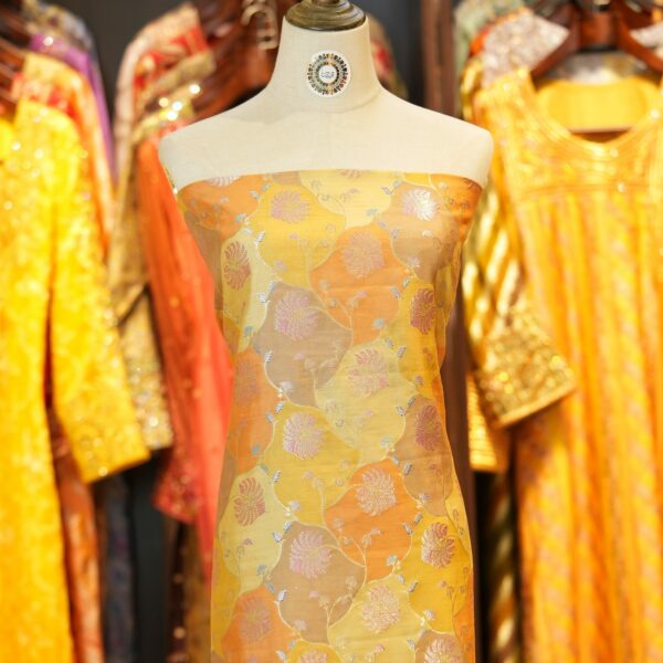 Amber orange and yellow Rangkaat silk fabric with silver and pink zari floral weave