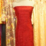 Deep saffron red embroidered pure silk fabric with delicate floral motifs and sequin highlights