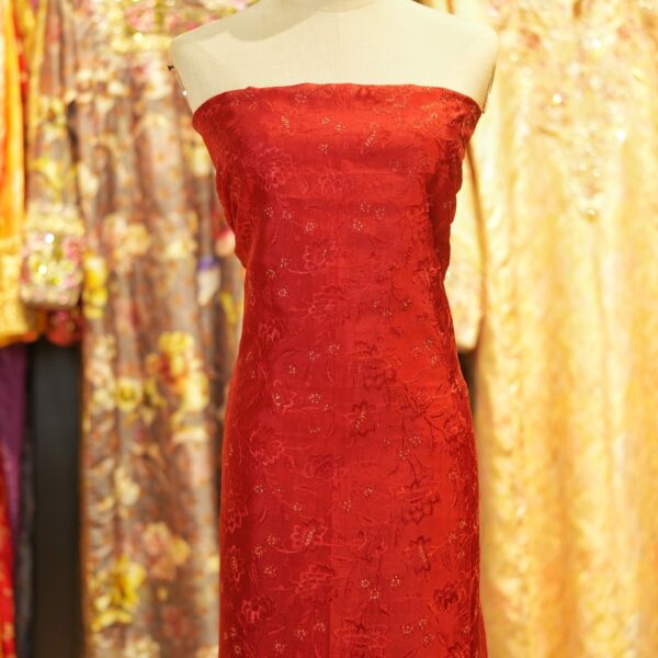 Deep saffron red embroidered pure silk fabric with delicate floral motifs and sequin highlights