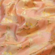 Blush peach Rangkaat silk fabric with multicolored floral zari weaving and soft pastel highlights