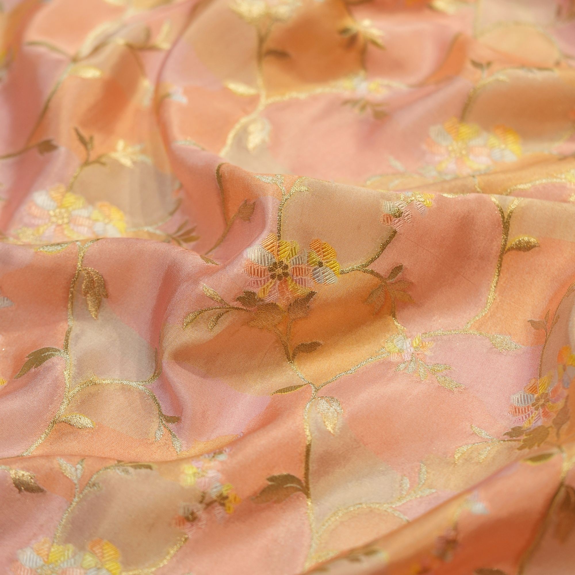 Blush peach Rangkaat silk fabric with multicolored floral zari weaving and soft pastel highlights