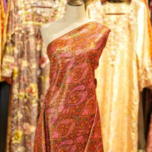 Pure silk brocade fabric with traditional paisley motifs in multicolor on a deep amber-orange base