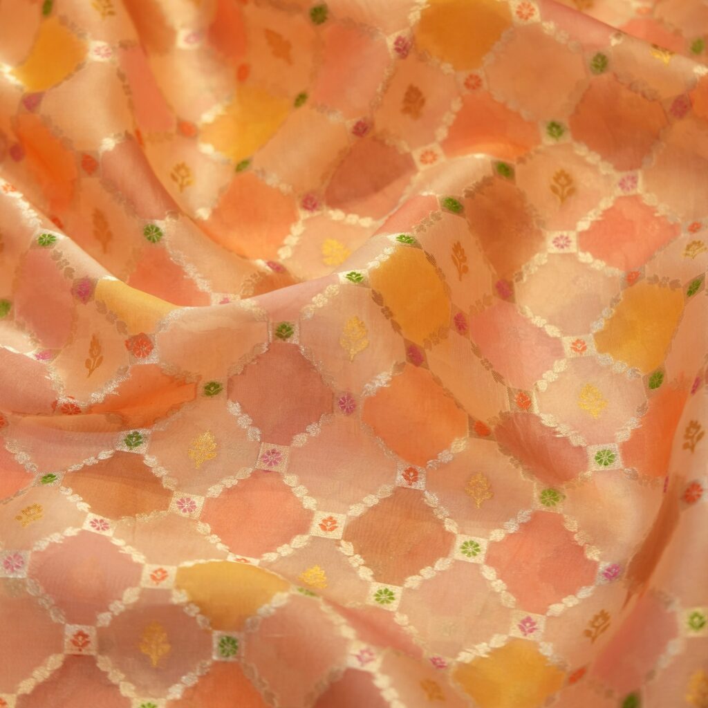 Peach and saffron pure organza Rangkaat fabric with golden zari diamond pattern and multicolor minakari motifs