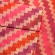 Luxurious pure organza fabric in gradient rangkaat tones with golden zigzag floral-bordered Zari weave.