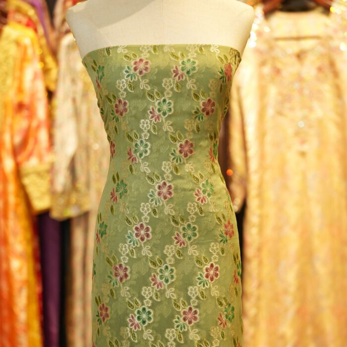 Green khaddi chiffon fabric with multicolored floral boota and hand-brush dye finish with zari highlights.