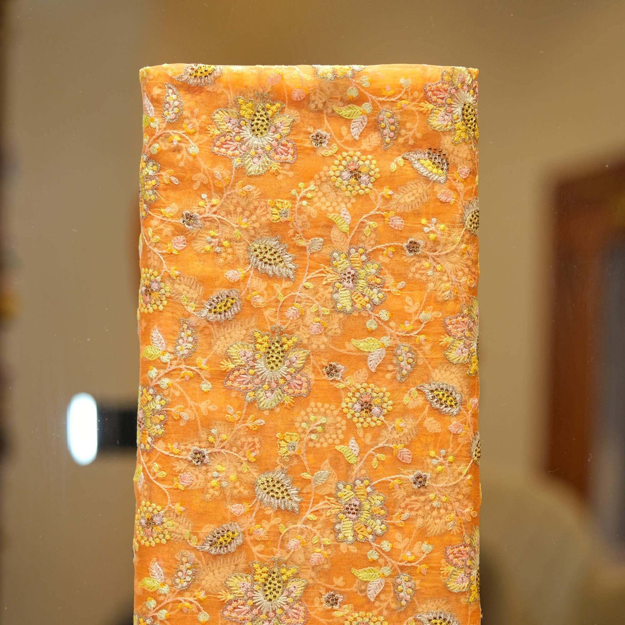 Golden orange pure organza fabric with intricate floral embroidery and shimmering crystal highlights – luxury festive material