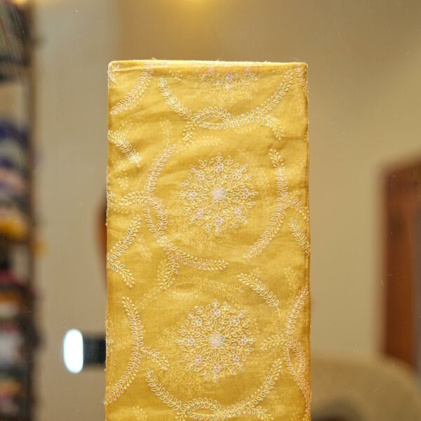 Golden yellow pure organza fabric with circular floral embroidery and delicate leafy weaves