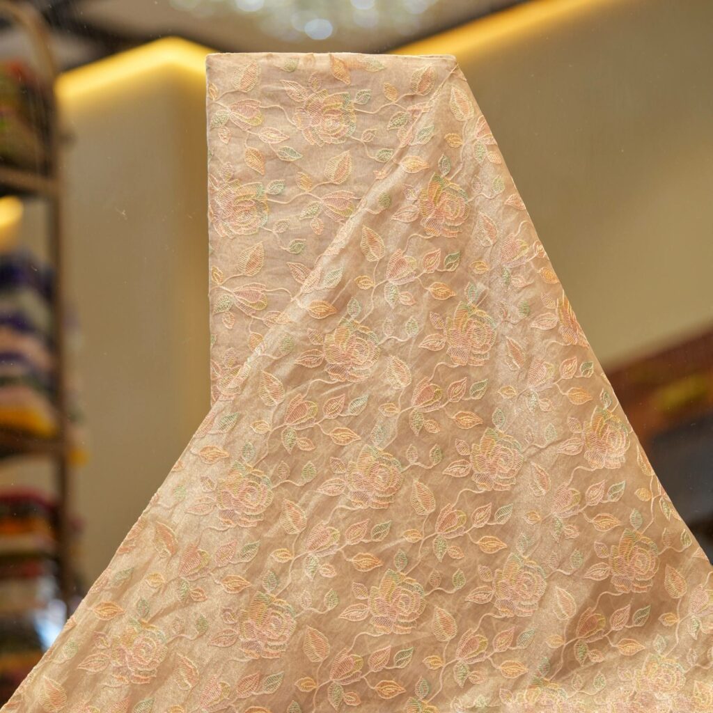 Golden tissue organza fabric with soft pastel floral embroidery and hand-dyed shading – luxury fabric for couture