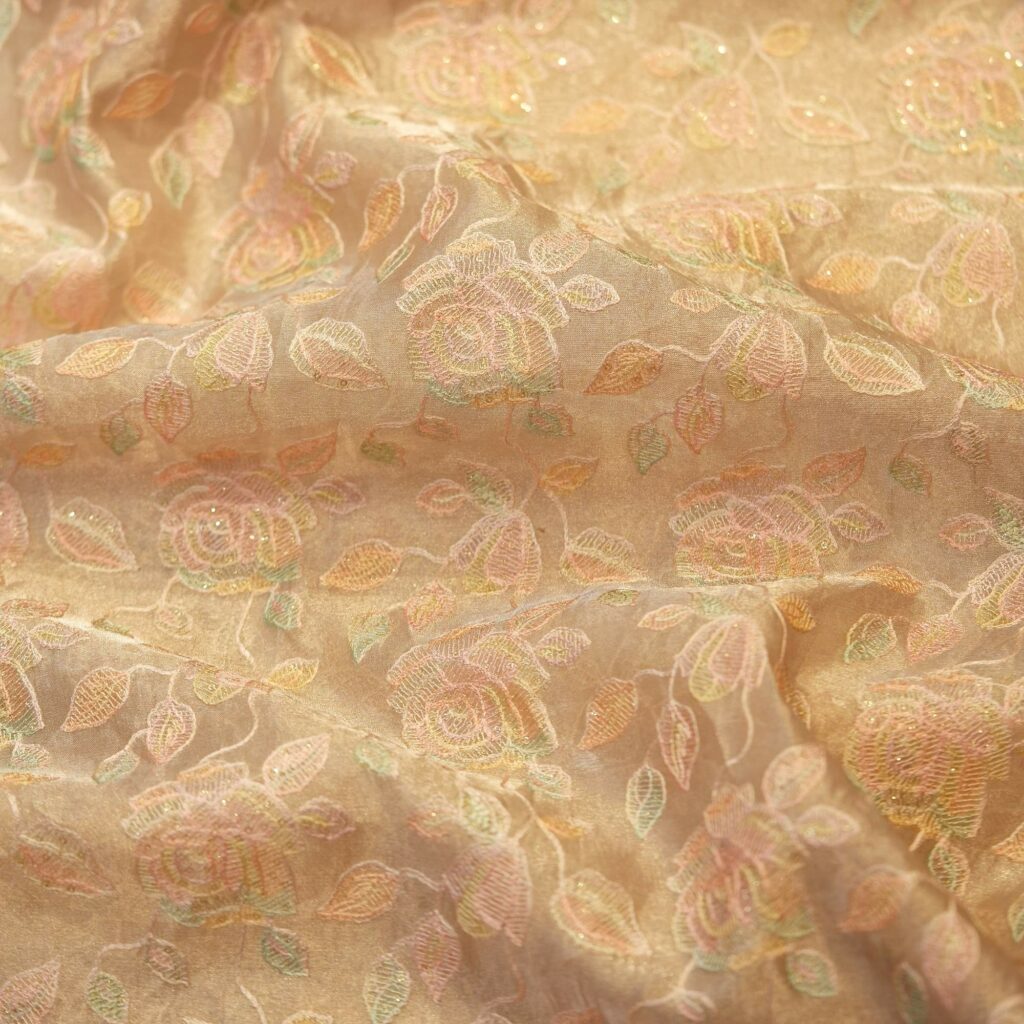 Golden tissue organza fabric with soft pastel floral embroidery and hand-dyed shading – luxury fabric for couture