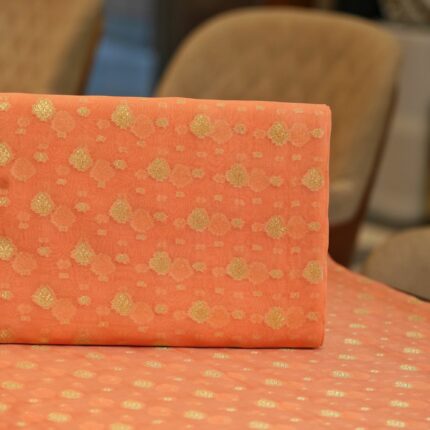 Peach pure organza fabric with golden zari woven floral motifs