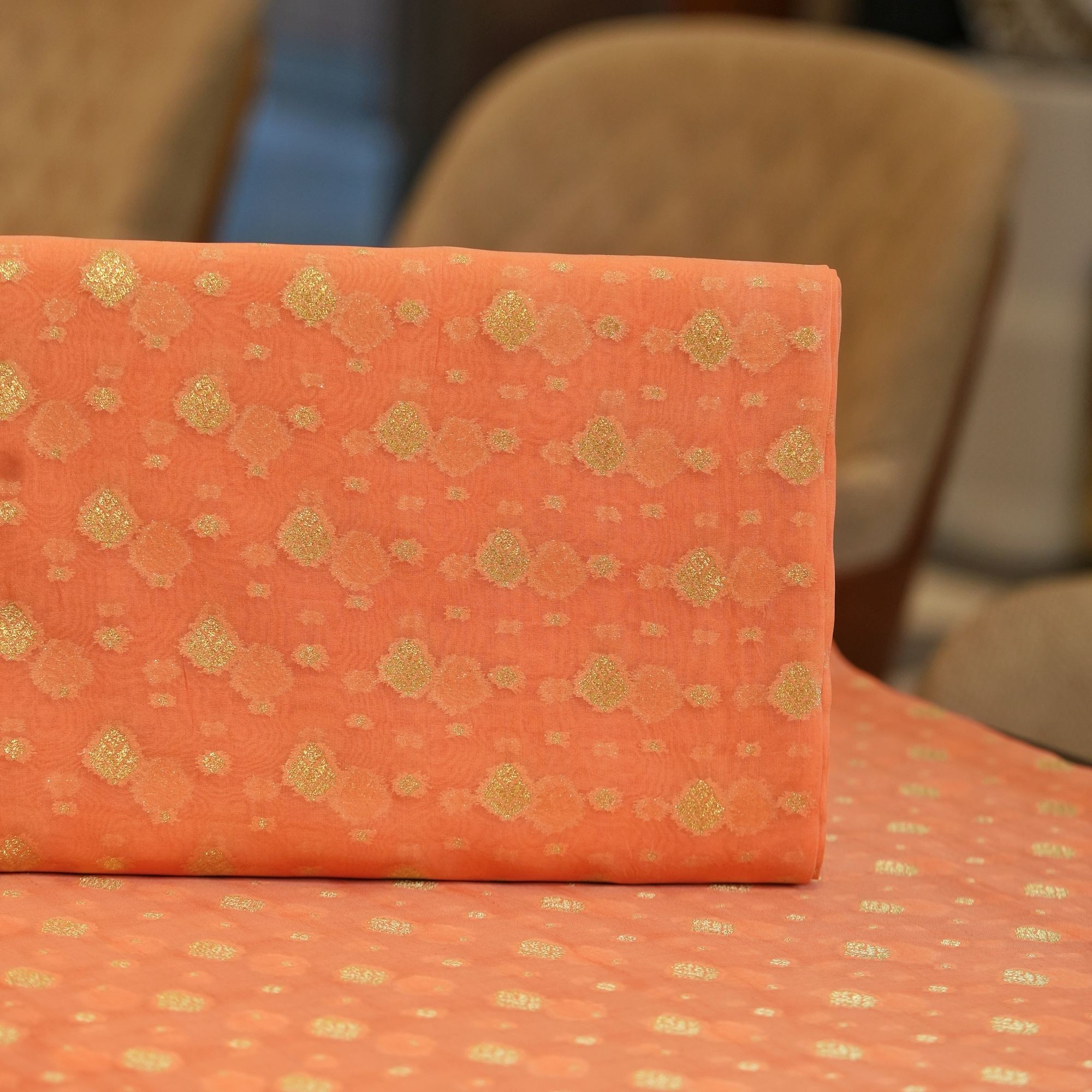 Peach pure organza fabric with golden zari woven floral motifs