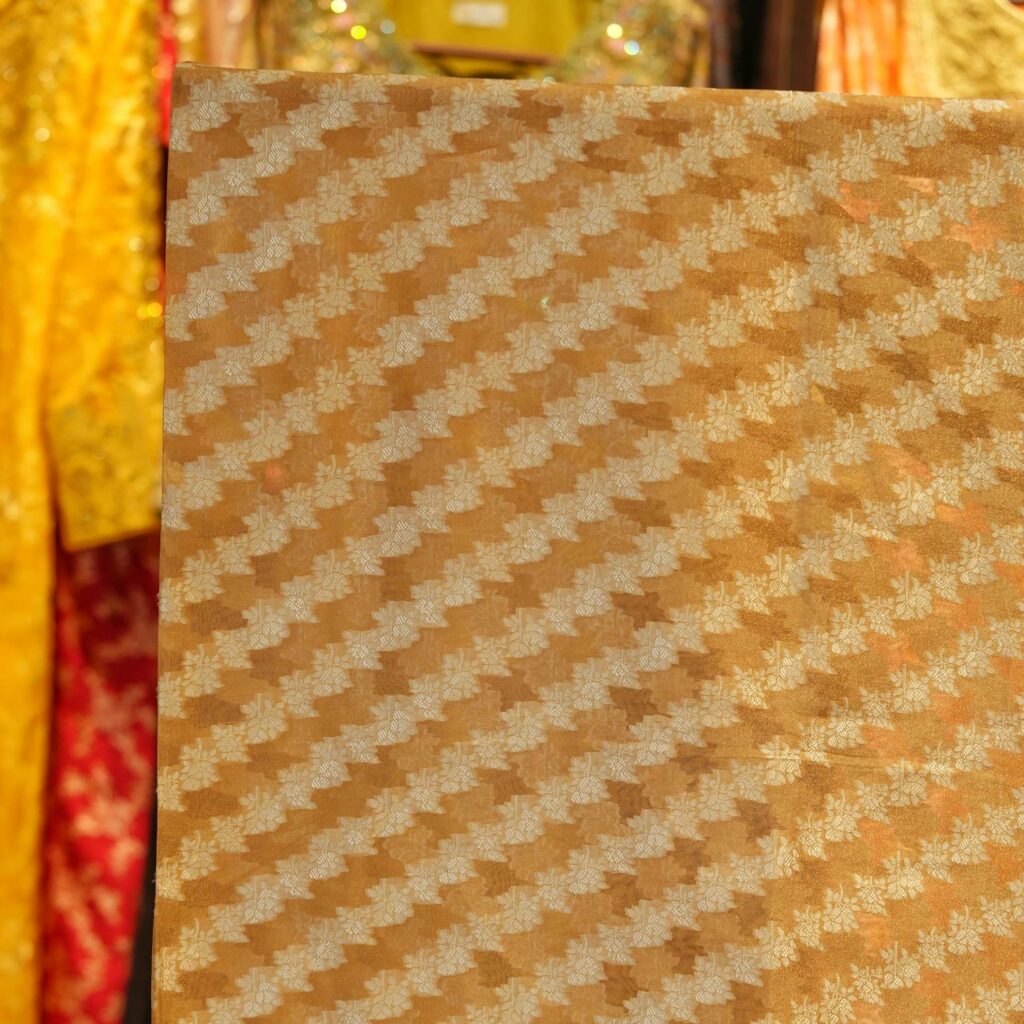 Golden pure organza fabric with cross-stripe zari jaal weave in floral patterns