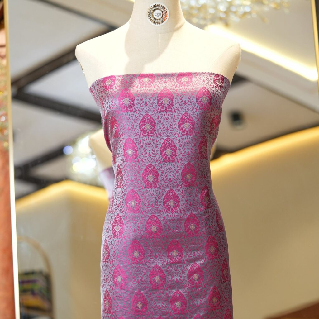 Pink tanchoi silk fabric with intricate jaal weave and subtle golden zari buti