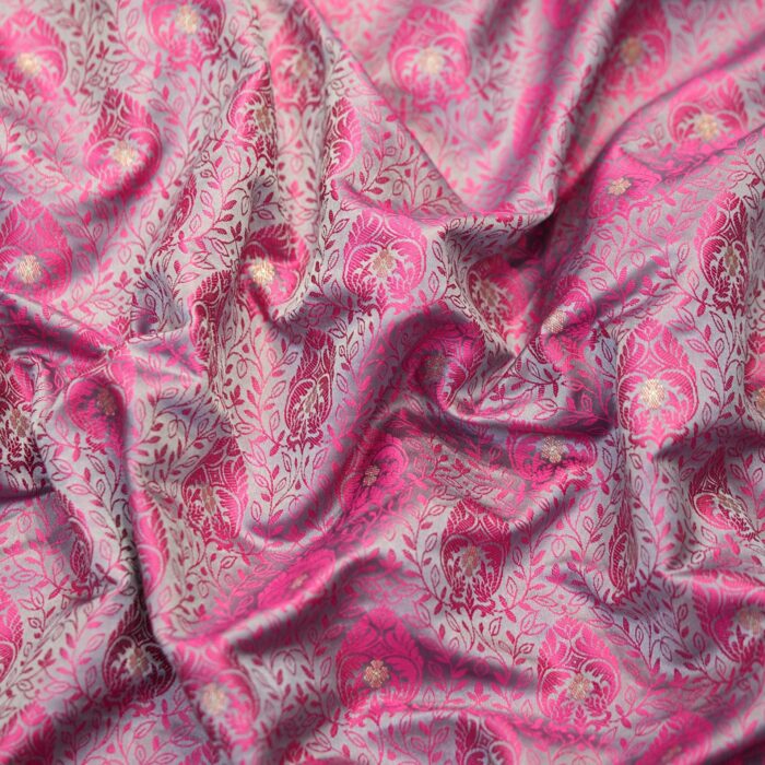 Pink tanchoi silk fabric with intricate jaal weave and subtle golden zari buti