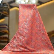 Tanchoi resham silk fabric with intricate floral weaving in crimson, lavender, and gold