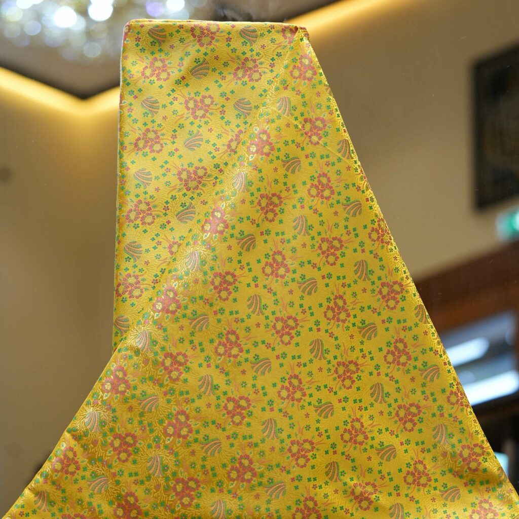 Lime yellow Resham silk fabric with floral motif and delicate multicolor weave