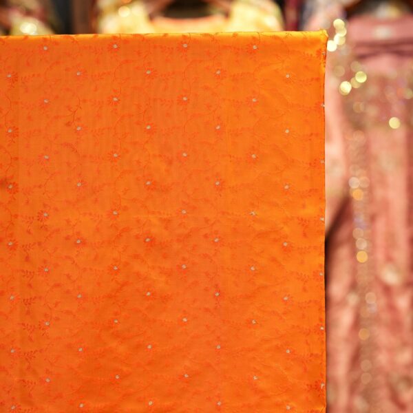 Handloom Tanchoi Jamawar silk in orange with Zari buti and woven floral pattern