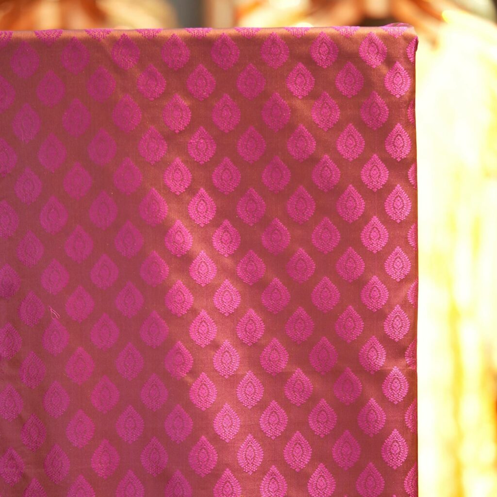 Pure handloom Tanchoi Jamawar resham silk fabric with geometric woven motifs in orange and magenta