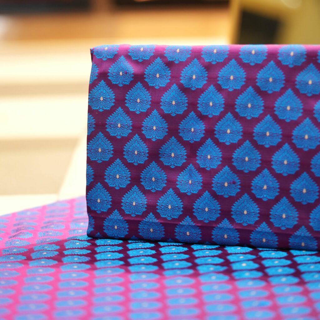 Pure handloom Tanchoi Jamawar resham silk fabric with Mughal blue leaf motifs on deep magenta base