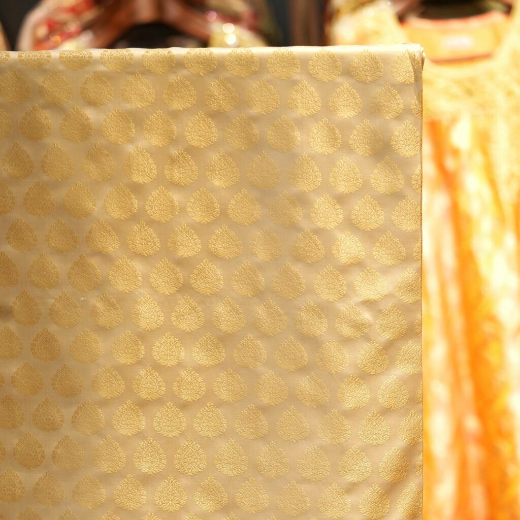 Pure handloom Tanchoi Jamawar resham silk fabric with Mughal leaf motifs in ivory and golden tones