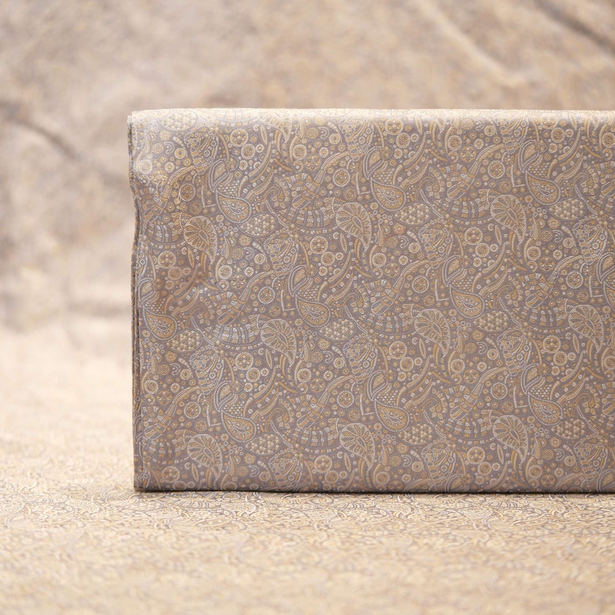 Elegant grey-beige Tanchoi jamawar handloom fabric in pure kataan silk with intricate paisley motifs
