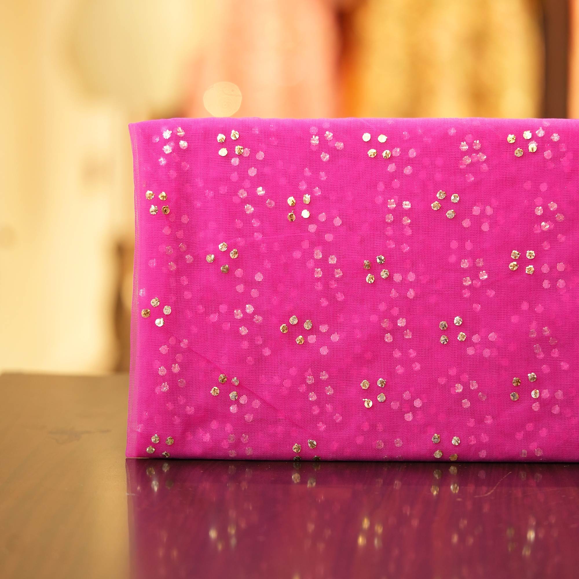 Pink net fabric with gold mukaish work in clustered dot pattern
