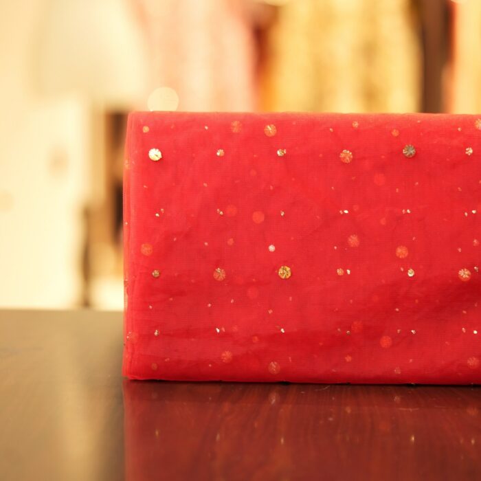 Red net fabric with scattered raindrop-style mukaish embroidery