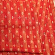 Rich red pure silk fabric with tissue jacquard stripes, golden zari weaving, and meenakari floral motifs