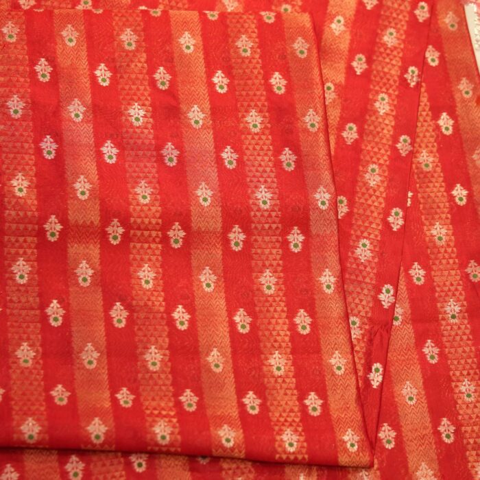 Rich red pure silk fabric with tissue jacquard stripes, golden zari weaving, and meenakari floral motifs