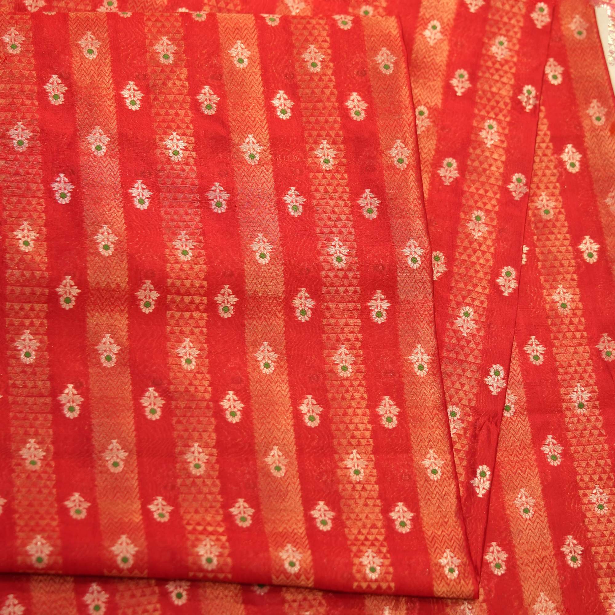 Rich red pure silk fabric with tissue jacquard stripes, golden zari weaving, and meenakari floral motifs