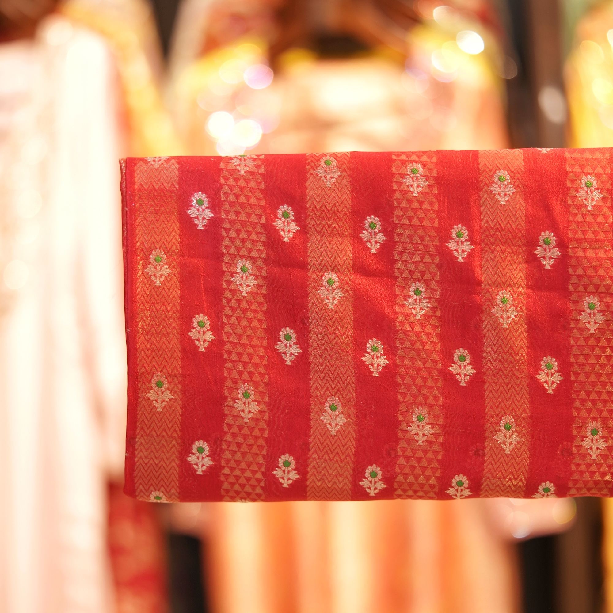 Rich red pure silk fabric with tissue jacquard stripes, golden zari weaving, and meenakari floral motifs