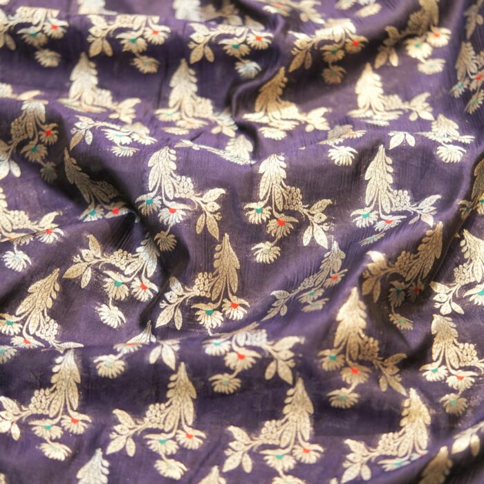 A refined navy blue dupion silk adorned with silver zari florals and subtle pops of meena work — perfect for contemporary thobes, statement pieces, or couture accents.