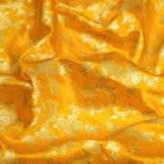 Bright yellow dupion silk fabric with light gold floral vine zari weaving