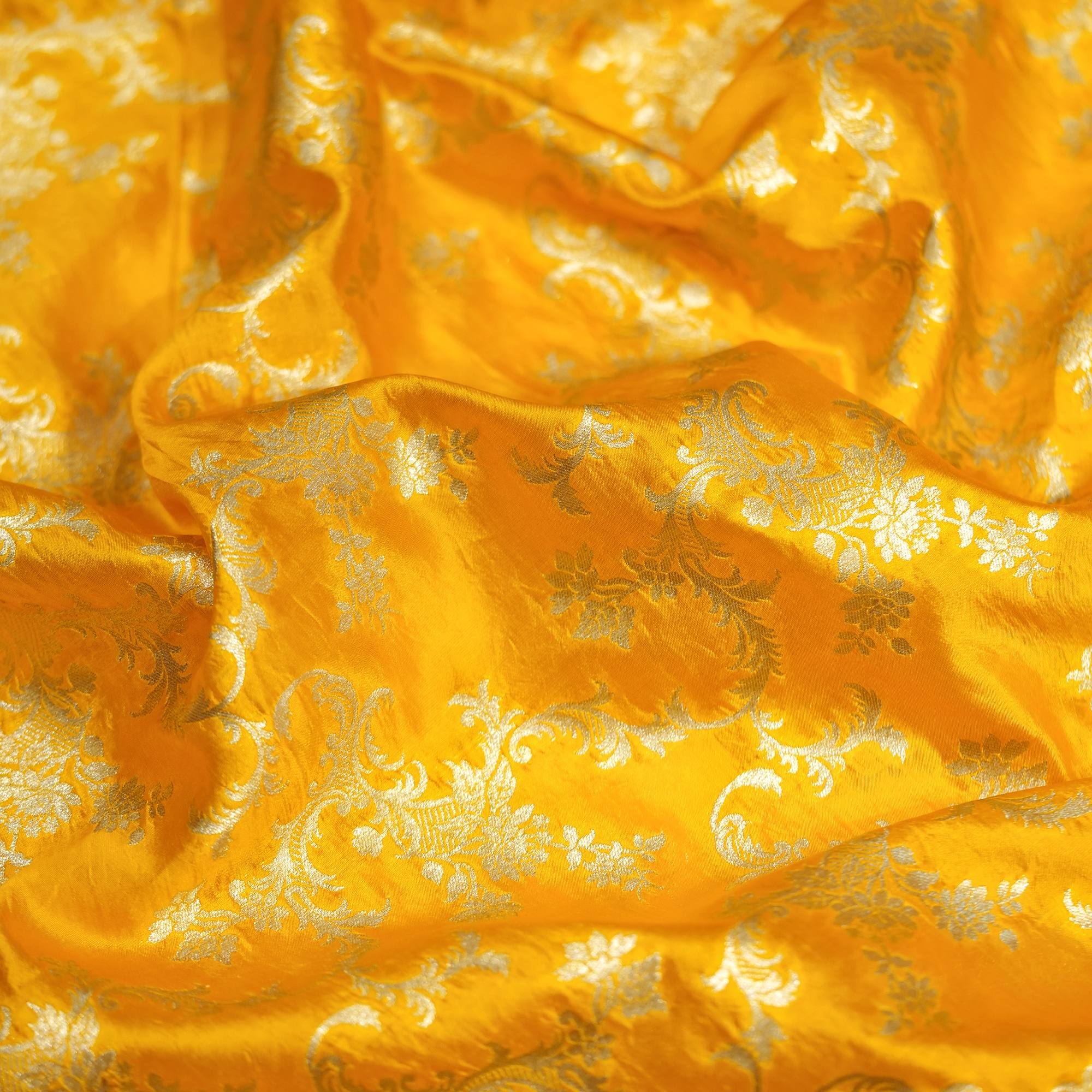 Bright yellow dupion silk fabric with light gold floral vine zari weaving