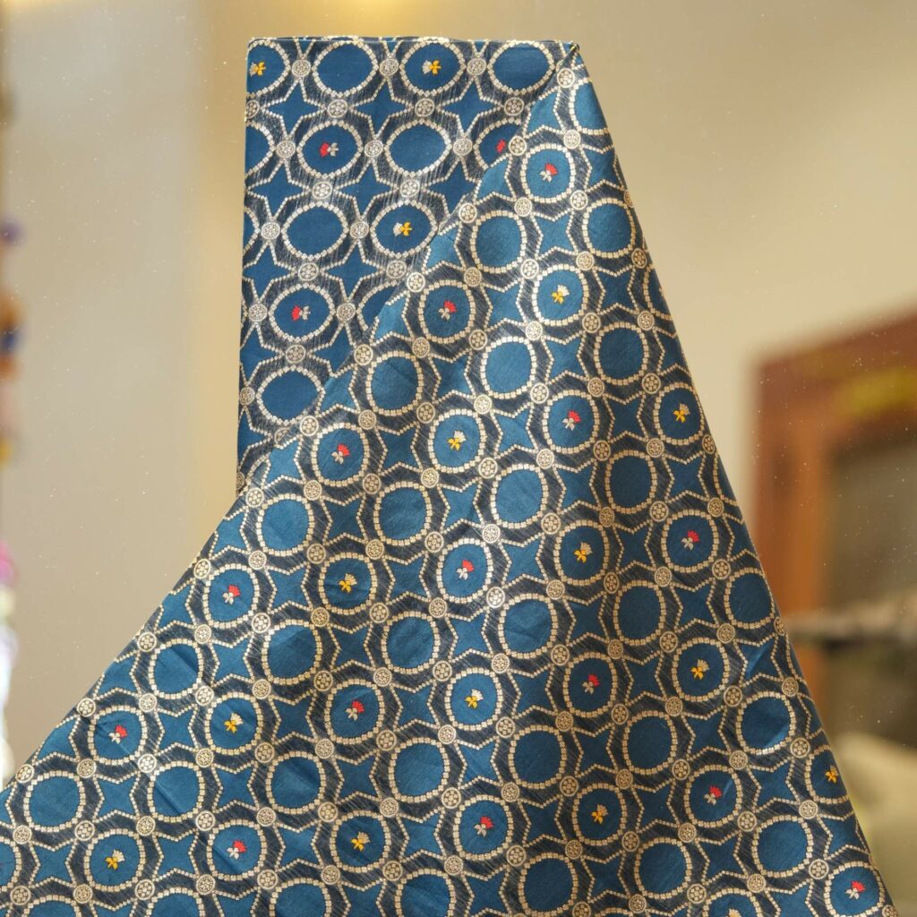 Teal dupion silk fabric woven with silver-gold Zari lattice circles and tiny red & yellow Meenakari accents – Zahiri collection