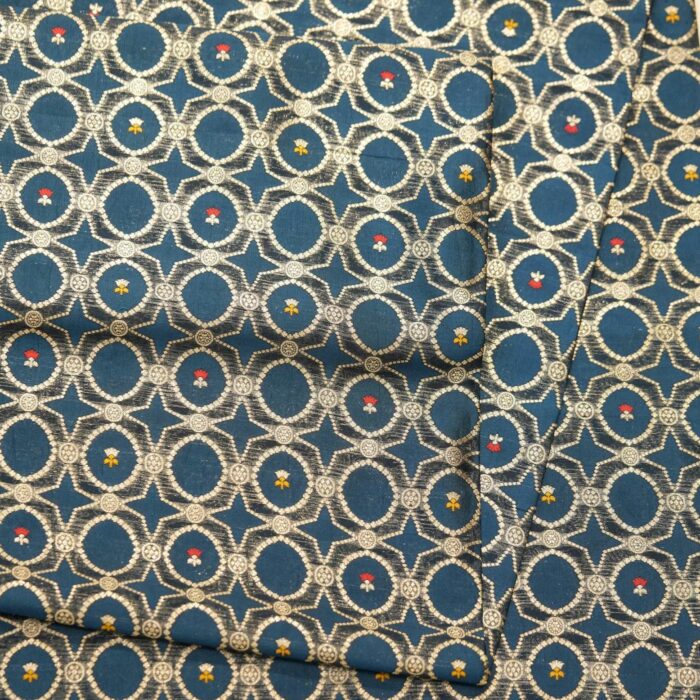 Teal dupion silk fabric woven with silver-gold Zari lattice circles and tiny red & yellow Meenakari accents – Zahiri collection