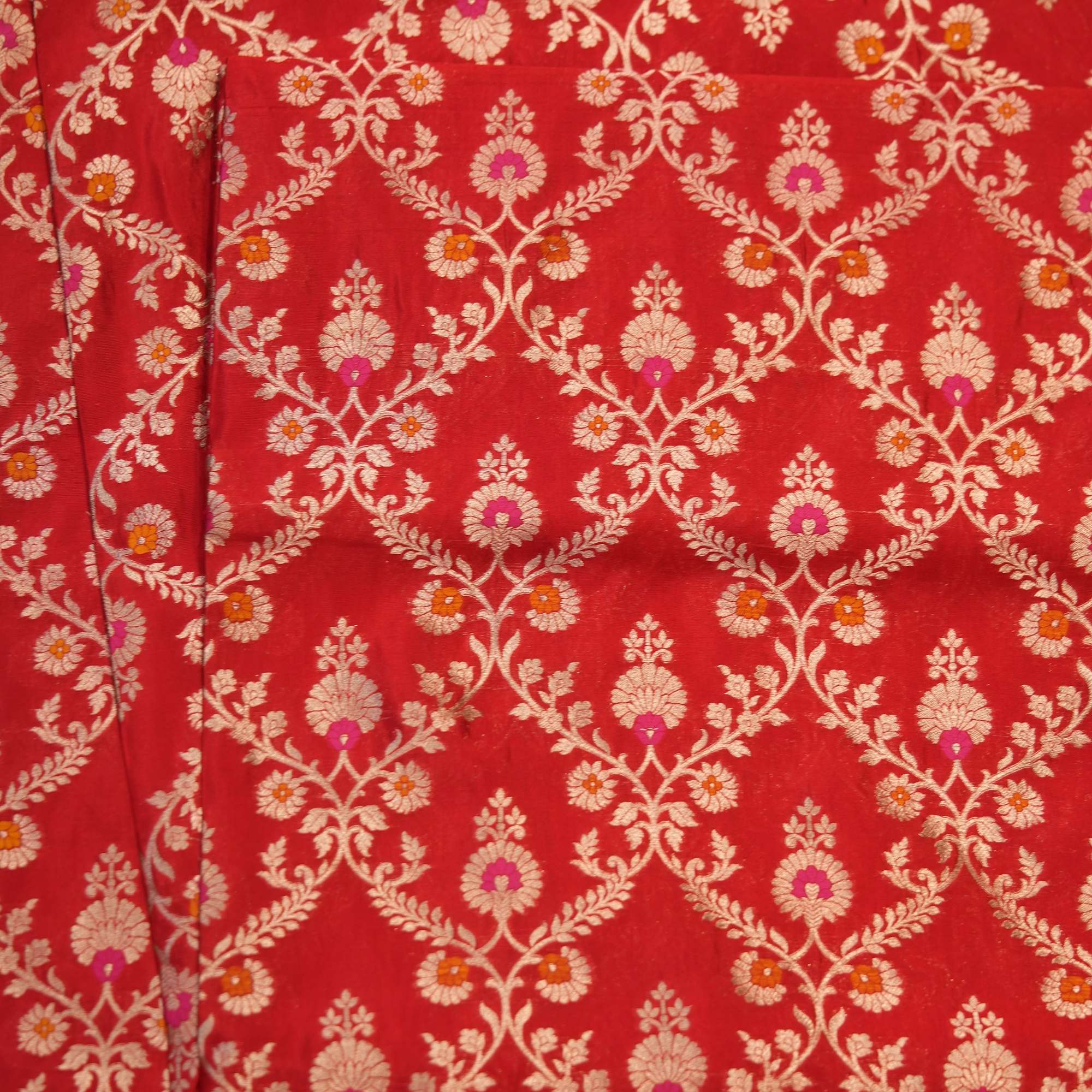 Red dupion silk fabric with intricate zari vines and colorful meenakari floral motifs