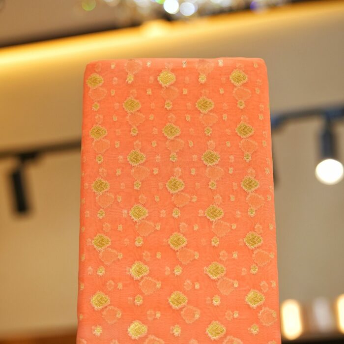 Peach pure organza fabric with golden zari woven floral motifs