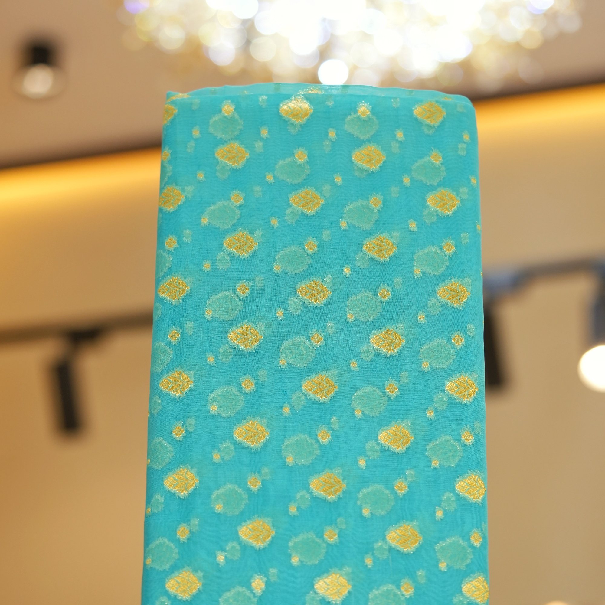 Turquoise blue pure organza fabric with golden zari floral woven motifs