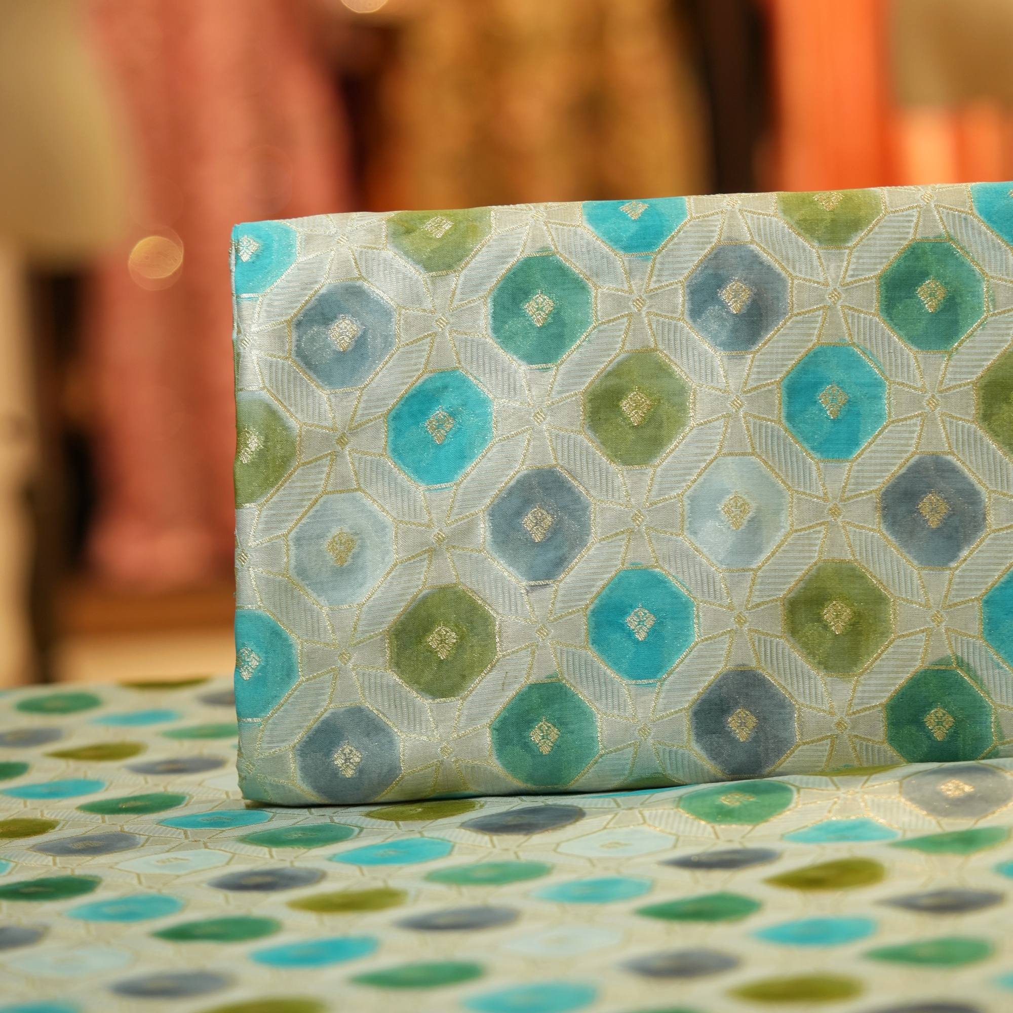 Katan silk fabric with golden Zari weave and green-teal Rangkaat dye in octagonal motifs
